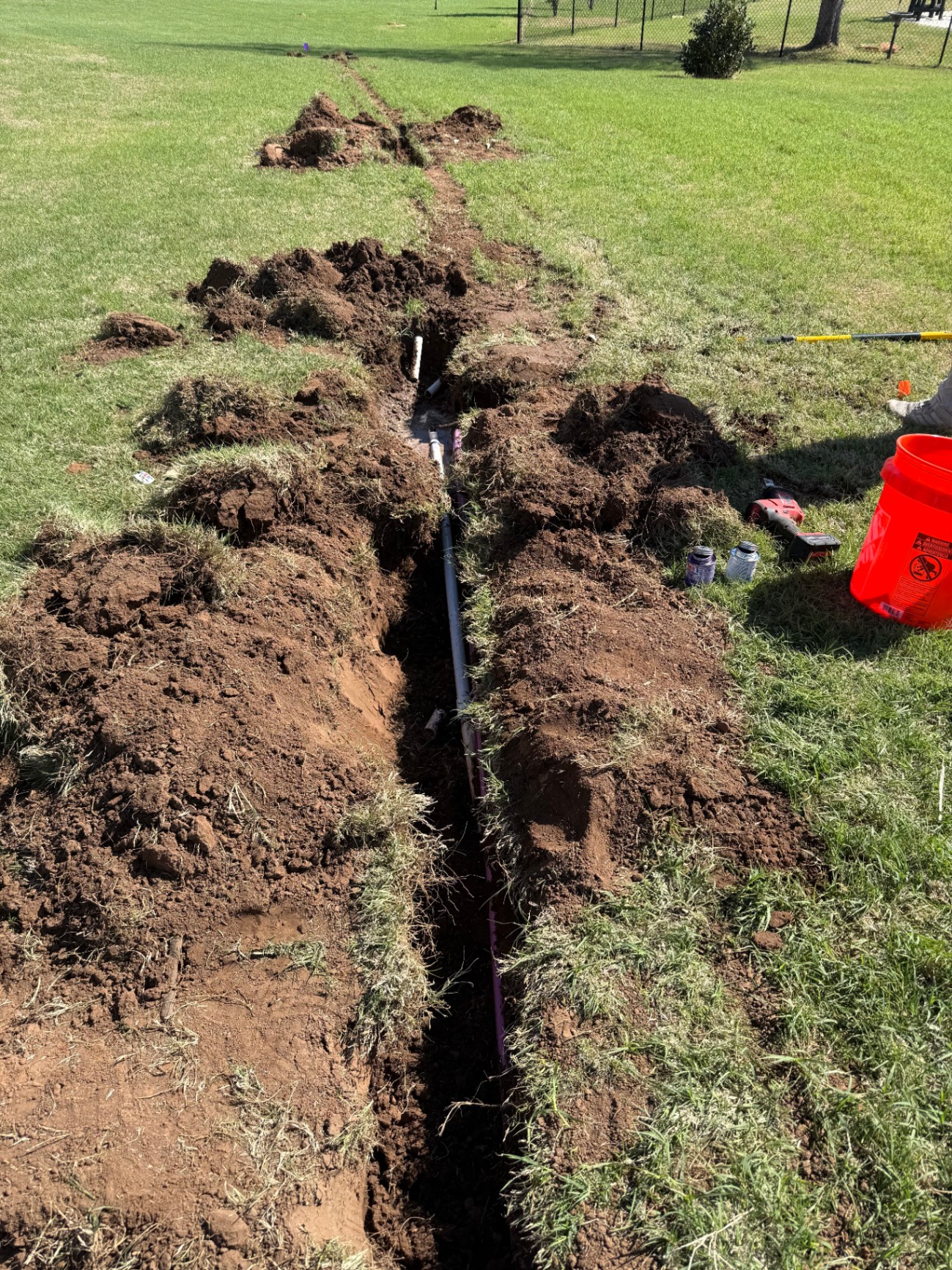 PVC sprinkler pipe laid through a long open trench in a Tuttle Oklahoma yard