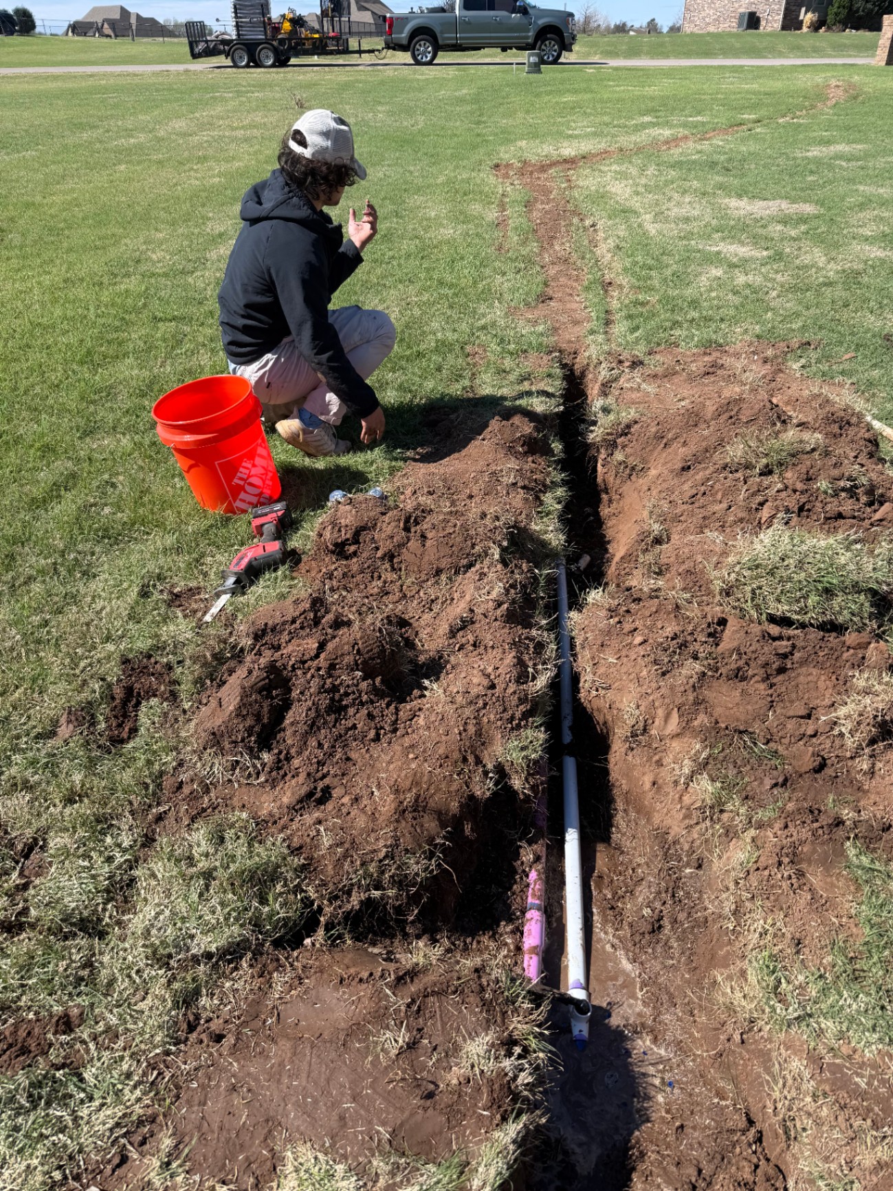 sprinkler heads staged along a freshly dug irrigation trench in a Tuttle Oklahoma yard