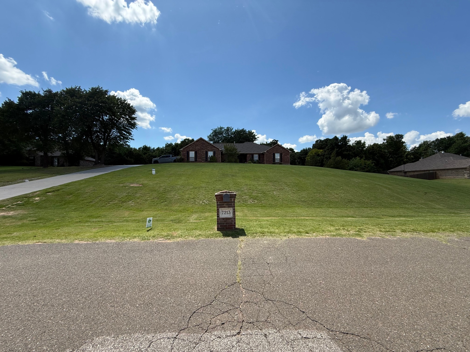 wide front lawn and brick mailbox on a large residential property after mowing in Tuttle Oklahoma